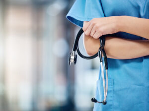 Closeup of nurse holding stethoscope.